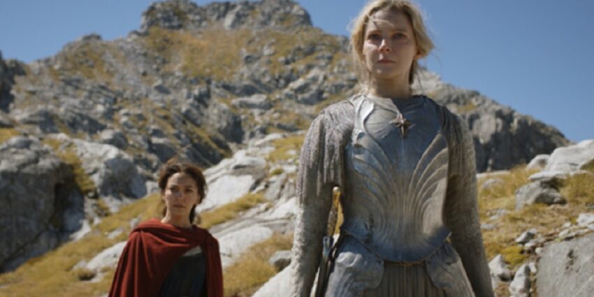 Two female characters in fantasy costume appear on a rocky headland