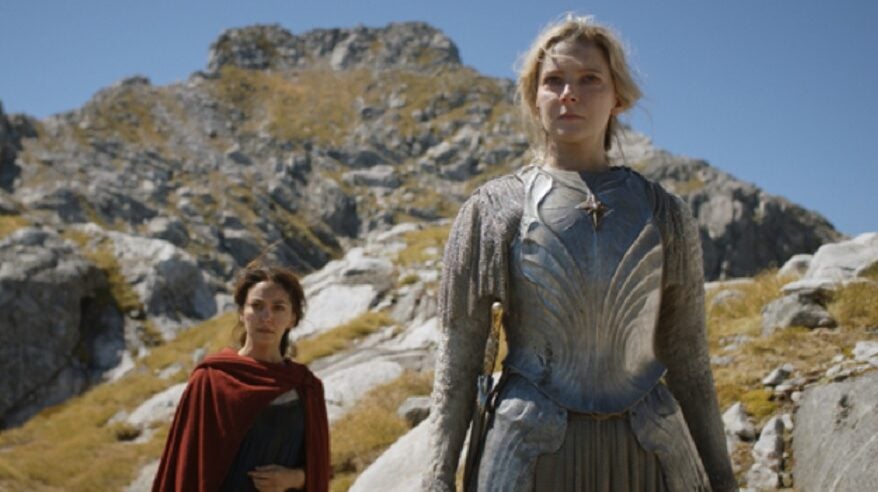 Two female characters in fantasy costume appear on a rocky headland