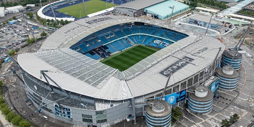 The huge Manchester City FC stadium shown from above with pale blue seating