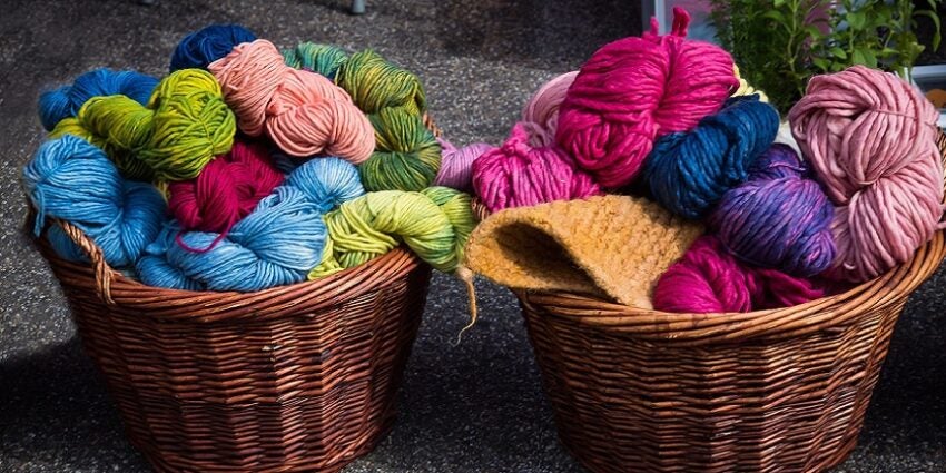 Very colourful balls of wool in two wicker baskets