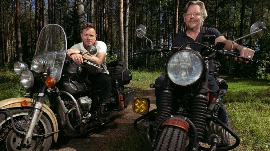 Ewan McGregor and Charley Boorman on their motorbikes in a forest