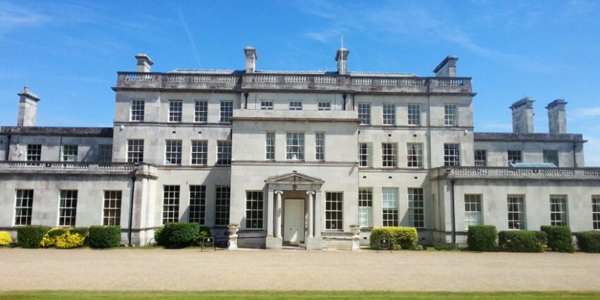 Front exterior of Addington Palace with lawn and sky