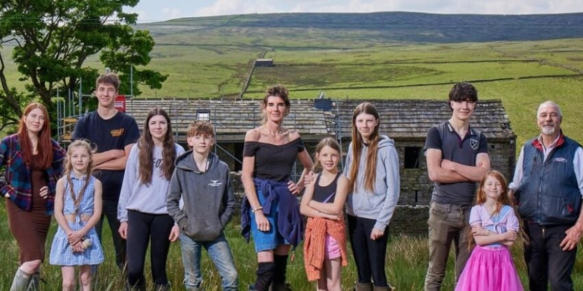 Amanda Owen and husband Clive with their nine children standing in a group outdoors