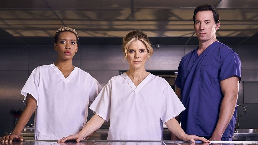 Three lead actors in BBC drama Silent Witness standing wearing scrubs