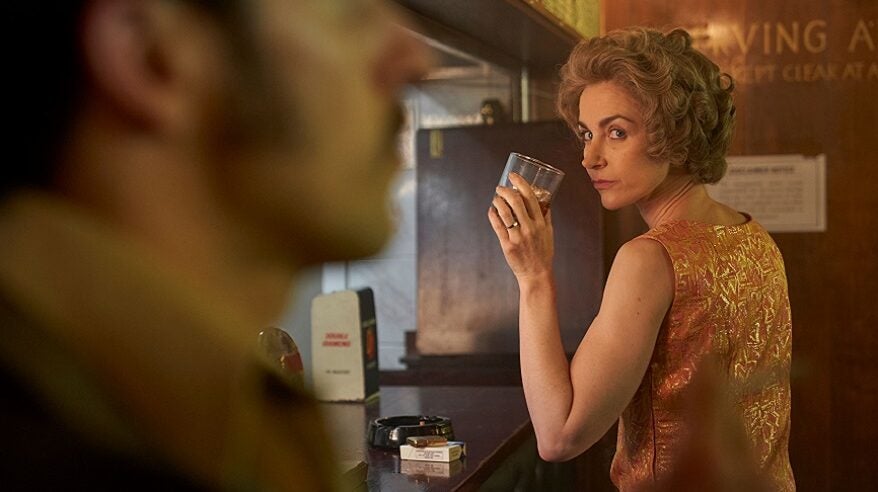 Actor Katherine Kelly in character sitting at a bar in TV drama the Long Shadow