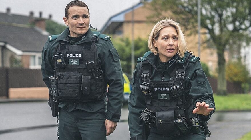 Actors Martin McCann and Siân Brooke in character as police officers on a residential street in BBC drama Blue Lights