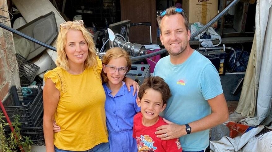 Presenter Jasmine Harman in yellow T-shirt, standing with her two young children and her husband