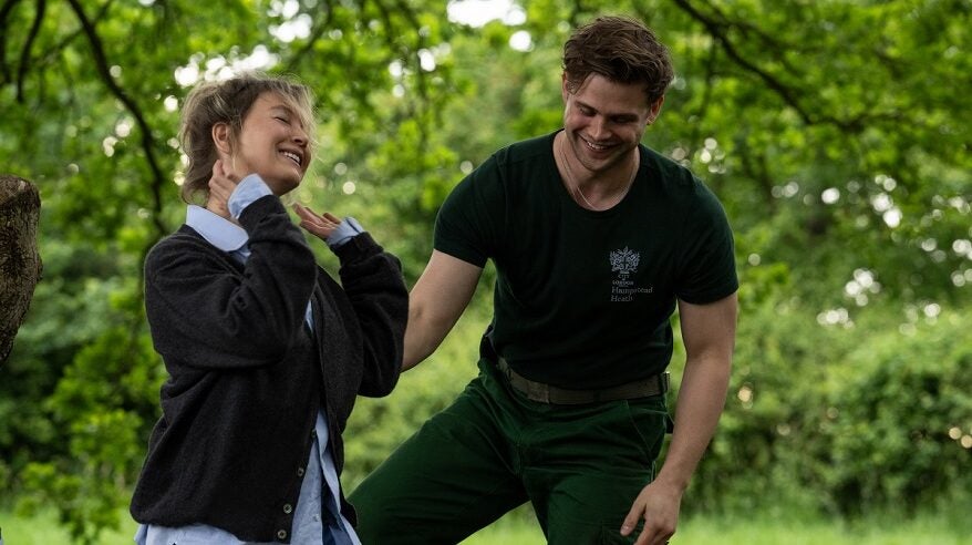 Renee Zellweger and Leo Woodall in character, standing by a tree in Bridget Jones: Mad About the Boy