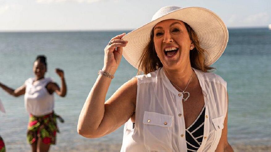 Singer and presenter Jane McDonald in a large sunhat on a beach