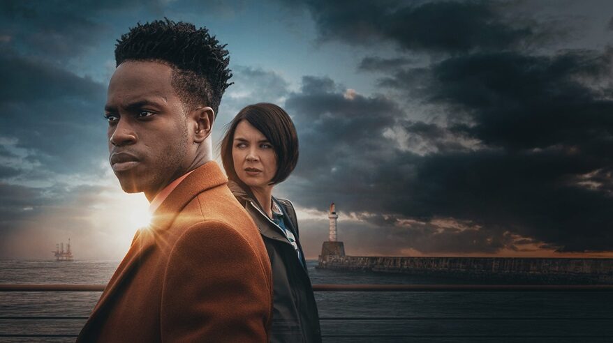 The two main characters from BBC drama Granite Harbour, standing against a coastal backdrop