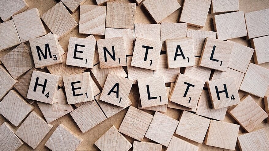 Brown wooden Scrabble tiles with letter on spelling out Mental Health