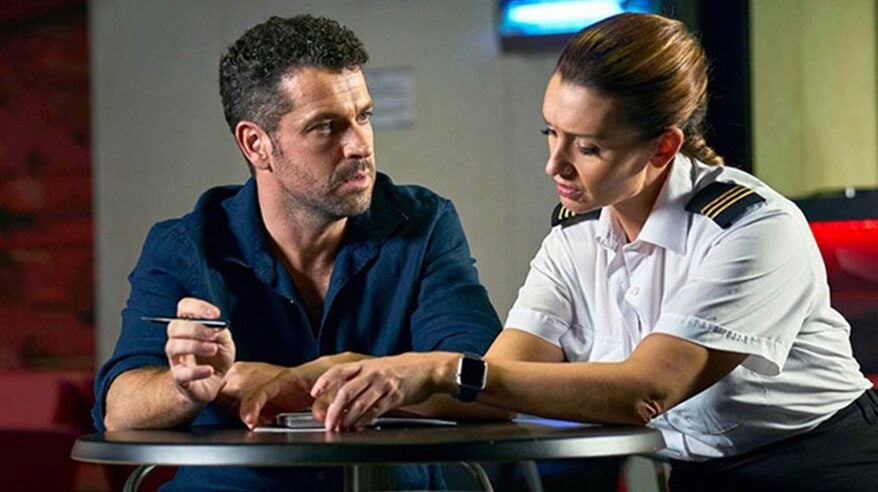 Actors Shayne Ward and Catherine Tyldesley, seated at a table in C5 drama The Good Ship Murder