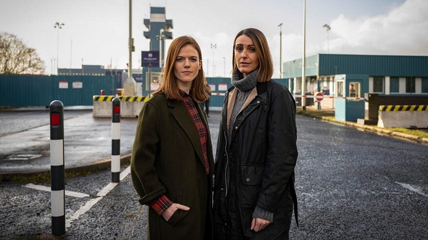 Actors Rose Leslie and Suranne Jones in BBC drama Vigil, standing on a road in dark coats