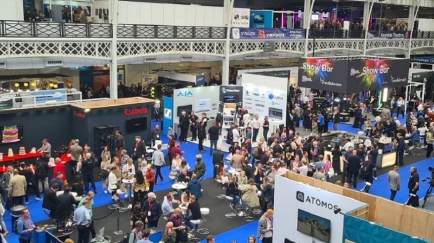 A busy exhibition hall with blue flooring
