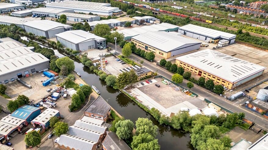 Aerial shot of Garden Studios, a film facility with several buildings seen alongside a river with lots of trees