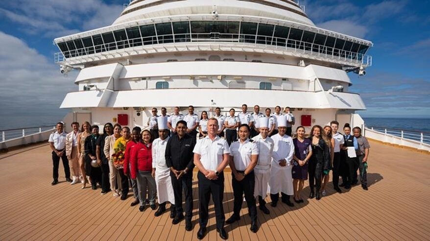 Crew lining up on deck of a luxury cruise ship