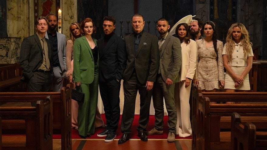 Cast of This City is Ours, in character, dressed for a wedding in a group shot