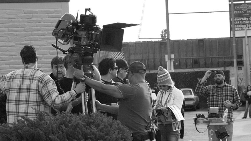 Black and white image of a film crew outdoors