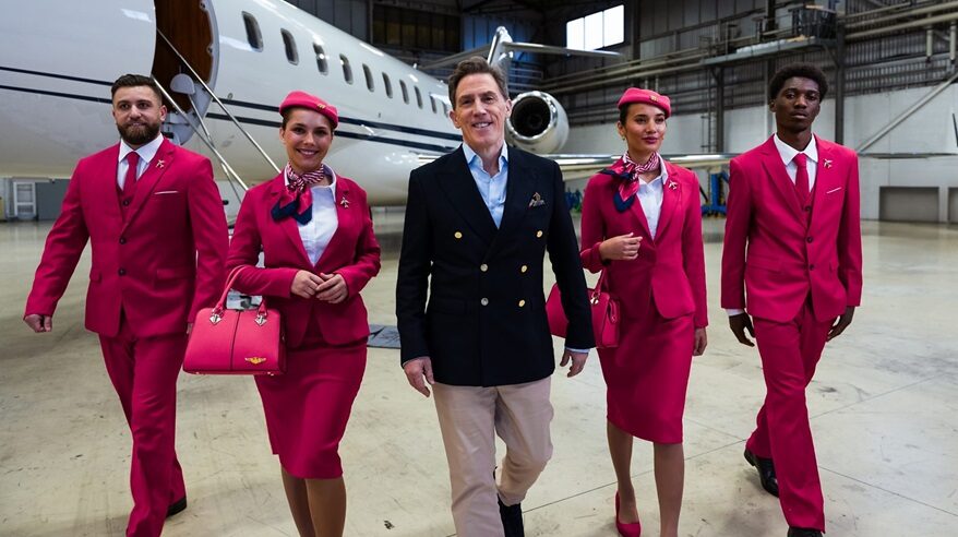 Rob Brydon and uniformed airline staff in front of an aeroplane in BBC show Destination X