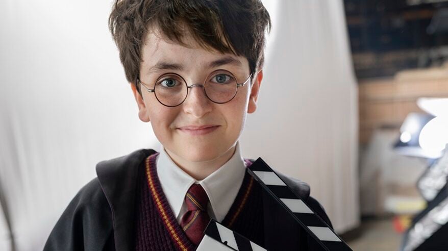 Young actor Dominic McLaughlin playing Harry Potter in new TV series, in costume with clipboard