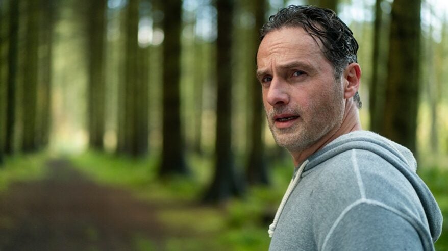 Actor Andrew Lincoln in grey hoodie in middle of woods turning to look over his shoulder, from ITV drama Coldwater