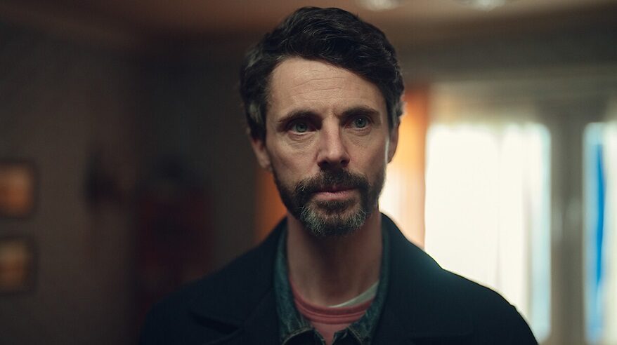 Actor Matthew Goode in Netflix drama Dept. Q, facing camera in shirt and dark jacket
