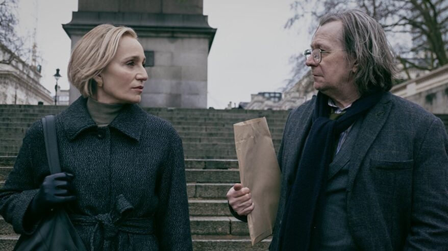 Actors Gary Oldman and Kristin Scott Thomas in TV drama Slow Horses standing in front of an outdoor stone staircase