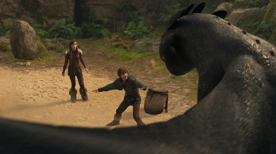 Child actors face a huge dragon in a scene from Universal film How to Train Your Dragon